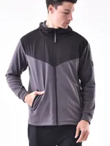 Campera deportiva azul con paneles negros en la parte superior y capucha. Cierre frontal con cremallera.