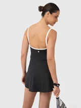Vestido enterito deportivo negro con breteles blancos y falda tipo skort.