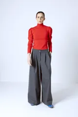 Polera roja de tejido de punto con cuello alto y mangas largas abullonadas en los hombros.