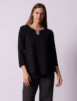 Blusa negra de tejido labrado marca Ruby Rd, con cuello redondo, escote en V y aplique metálico en el escote. Manga tres cuartos.