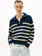 Sweater de punto con cuello alto y cierre de cremallera metálica, diseño de rayas horizontales en azul marino y beige, logo de Tommy Hilfiger bordado en el pecho. Confeccionado en algodón.