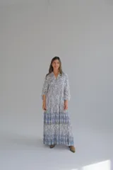 Vestido largo celeste y blanco con estampado geométrico, escote en V y mangas 3/4.