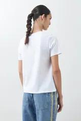 Remera blanca de algodón con estampa de motivos playeros en tonos marrones.