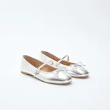 Manoletinas plateadas brillantes con correa sobre el empeine y lazo decorativo en la punta.