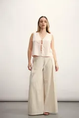 Pantalón palazzo a rayas verticales color beige y blanco, de tiro alto y corte amplio.