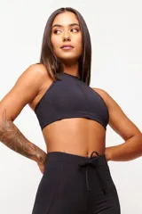 Top deportivo negro con cuello halter y espalda descubierta. Confeccionado en poliamida y elastano con protección UV50+.