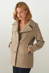 Chaquetón marrón de lana con cuello, abrochadura simple con botón en el cuello, bolsillos ojal y detalle de martingala en mangas.