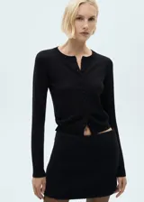 Minifalda negra de tweed, corte evasé y cierre trasero invisible.