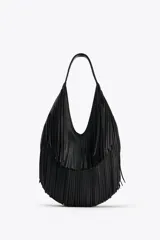 Bolso de hombro negro con flecos en el cuerpo, asa de hombro, bolsillo interior con cremallera y cierre mediante imán.