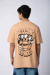 Remera gris con efecto acid wash, corte holgado y estampa frontal con una mano sosteniendo el mundo VCP.