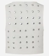 Top cropped sin mangas, color blanco, con escote redondo y tachuelas metalizadas distribuidas por toda la prenda. Posee cierre lateral de cremallera.