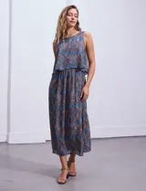 Vestido largo sin mangas de gasa estampada en tonos azules y marrones. Presenta escote redondo y corte en la cintura con punto smock.