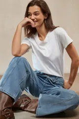 Pantalón de jean negro de tiro alto, corte ancho y pierna recta, con costuras verticales marcadas en el frente y cordón ajustable en la cintura.