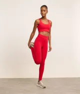 Top deportivo alargado color rojo, confeccionado en microfibra con escote en U, tiras finas cruzadas en la espalda y cintura ancha. Incluye copas removibles.