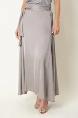 Pollera larga de satén de seda color beige, con cintura elástica y lazo decorativo.