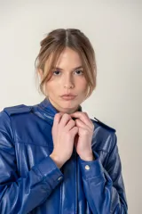Campera roja de cuero ovino italiano, con charreteras en los hombros, bolsillos laterales, broches ocultos en el frente y broches a la vista en cuello y puños.