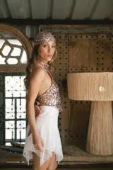 Top halter de lentejuelas color rosa, con cuello alto y diseño de espalda descubierta.