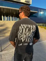 Remera gris nevada de corte holgado con estampado frontal de la frase "Brooklyn New York".