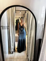 Vestido largo confeccionado en tejido con lurex color azul y detalles de encaje negro. Presenta un diseño entallado con escote profundo en V, espalda descubierta con tiras cruzadas y falda fluida con inserciones de encaje.