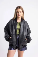 Campera bomber color amarillo pastel de cuero vacuno, con cierre delantero y bolsillos. Tiene puños, cuello y pretina de algodón.