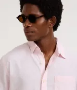 Camisa de hombre de manga corta color arena, confeccionada en lino y algodón. Tiene cuello camisero, corte clásico, cierre frontal con botones, un bolsillo en el pecho y ruedo recto.