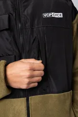 Campera negra con la parte superior de tela tipo rompevientos con dos bolsillos con solapa y la parte inferior de micro polar. Tiene cierre frontal y cuello alto.