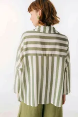 Camisa celeste y blanca a rayas verticales, de corte holgado y mangas largas.