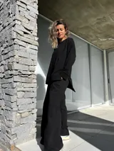 Conjunto negro compuesto por un remerón oversize de mangas largas y un pantalón palazzo de tiro alto con elástico en la cintura.
