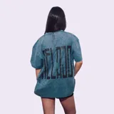 Remerón de manga corta, color gris jaspeado, con estampado grande en la espalda con texto vertical en negro.