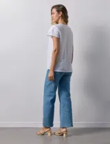 Blusa blanca de tejido pointelle con manga corta con volados y cuello redondo.