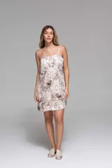 Vestido corto de tirantes finos, con estampado zodiacal en tonos amarillo, marrón y azul sobre fondo blanco.