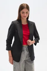 Blazer color crema de poliéster, de corte entallado, con cuello solapa y mangas largas.