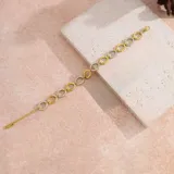 Pulsera dorada con eslabones ovalados, algunos con circonias blancas. Fabricada en acero quirúrgico con baño de oro 18k.