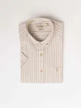 Camisa de manga corta a rayas verticales color beige y blanco, con cuello abotonado y bolsillo en el pecho.