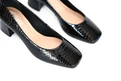 Zapato de cuero negro con acabado grabado, taco cuadrado de 5 cm y puntera ligeramente cuadrada y redondeada.