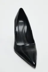 Zapato de tacón fino negro, con escote redondo y acabado en punta.