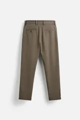 Pantalón slim fit negro confeccionado en tejido con elasticidad en ambas direcciones. Cuenta con bolsillos frontales y traseros de vivo con botón. Cierre frontal con cremallera y botón.