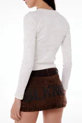 Remera manga larga de tela morley color beige con estampado BLKMBA a tono.
