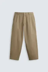 Pantalón color caqui de corte amplio, con pinzas en la cintura, bolsillos laterales y traseros con botón.