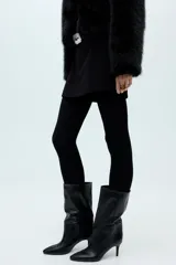 Bota de cuero sintético color negro, con caña media de efecto arrugado, punta fina y tacón fino.