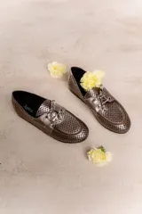 Náuticos color beige con diseño calado geométrico, cordones decorativos y suela marrón.