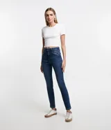 Pantalón skinny de jeans azul oscuro, con trabillas en la cintura, cierre de botón y cremallera, bolsillos delanteros y traseros con recortes diagonales.