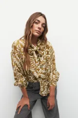 Camisa de manga larga con estampado orgánico en colores negro y blanco, con delicados botones de nácar y tiras para atar en el cuello.