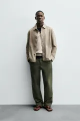 Cazadora de hombre de corte regular fit, confeccionada en piel con acabado ante color beige claro. Presenta cuello solapa, manga larga con puño de botón, bolsillos de plastrón en la cadera y cierre frontal con botonadura.