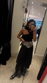 Vestido midi negro con estampado de lunares blancos, breteles finos y falda con volados y transparencias.