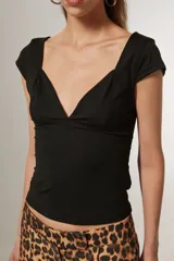 Top blanco de manga corta, ajustado al cuerpo y con escote profundo en V.