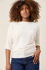 Blusa color rosa claro de hilo con textura acanalada horizontal, escote bote y mangas 3/4. Corte holgado.