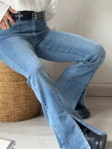 Pantalón de jean celeste con corte semioxford, tiro alto, bolsillos delanteros y traseros, y aberturas en el ruedo.
