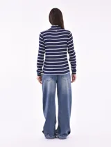 Polera de punto azul marino con rayas horizontales blancas, cuello alto y mangas largas.