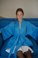 Kimono turquesa de camisería con cuello mao, pretina ajustable y desmontable, y bolsillos laterales invisibles.